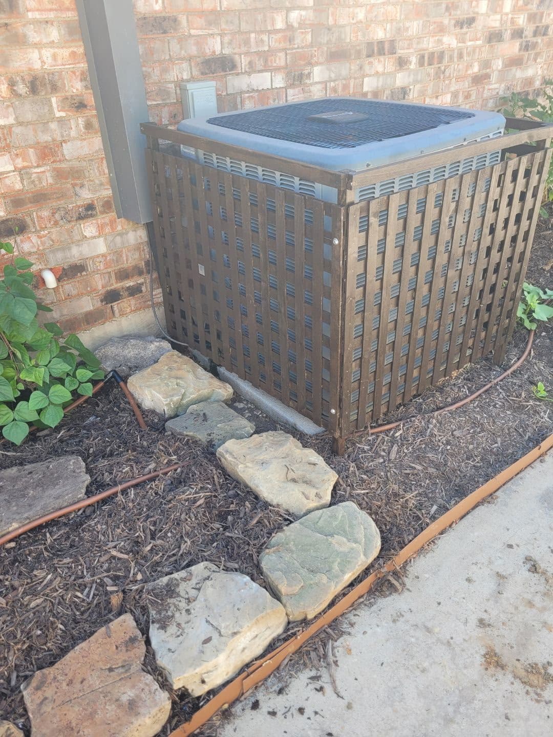 Slatted wooden enclosure for an outdoor condenser unit.